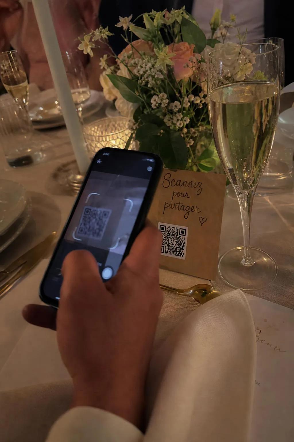 Une invitée scanne le QR code pour partager ses photos du mariage