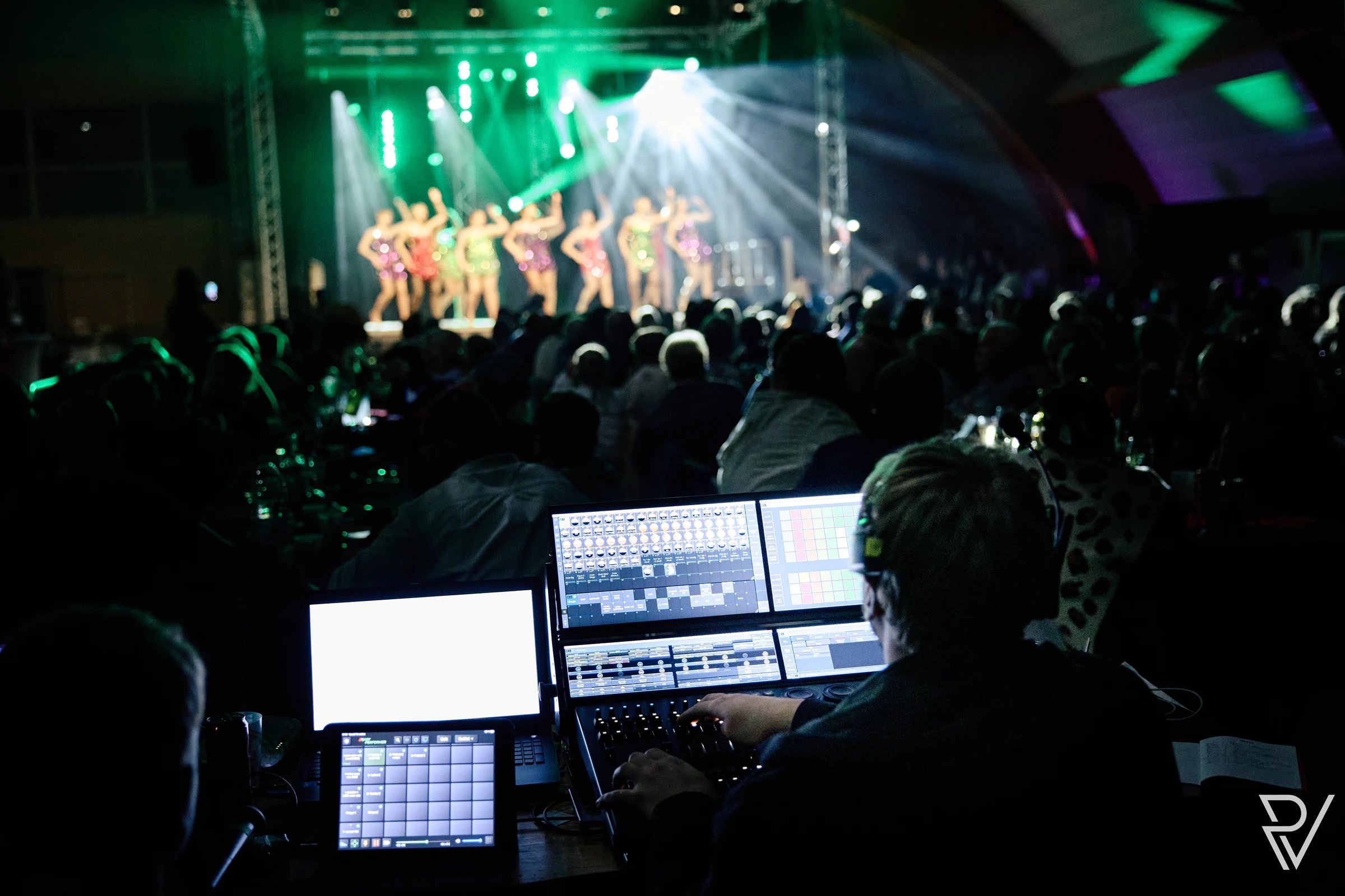 Spectacle cabaret sur la scène du salon, vu depuis la régie lumière, devant une salle comble