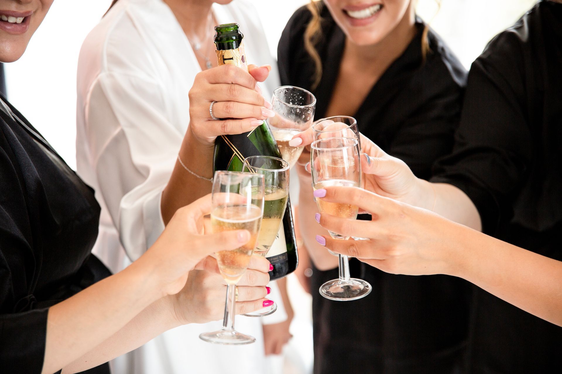 Groupe d'amies en peignoir trinquant au champagne avant la cérémonie
