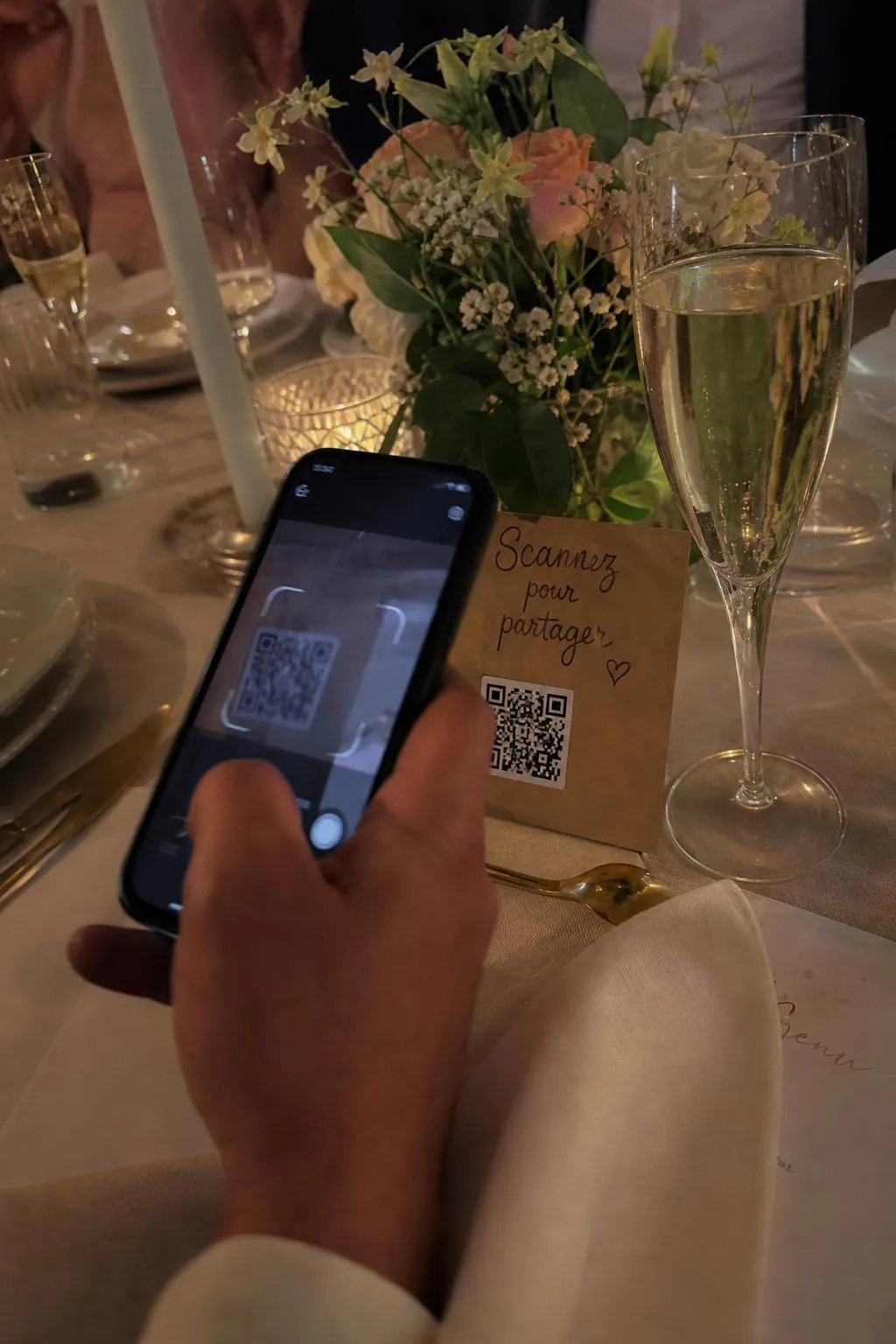 Invité qui scanne le QR code Photora avec son téléphone, à table.